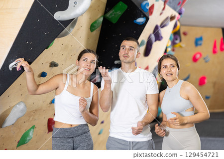 Young women and man - group of friends stand actively relaxing in climb hall 129454721