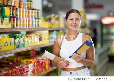 Young woman choosing pasta in store 129455329