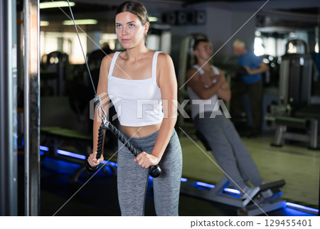 Young woman training with straps in gym 129455401