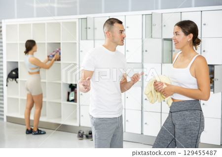 Young man and woman talking in locker room 129455487