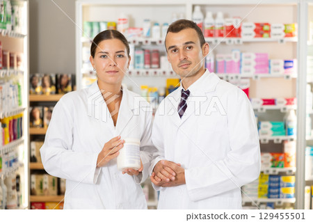 Young male and female pharmacists posing together in chemist's shop Young male and female pharmacists posing together in chemist's shop 129455501