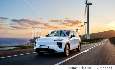 Electric car driving on road near wind turbines at sunset Electric car driving on road near wind turbines at sunset 129455531