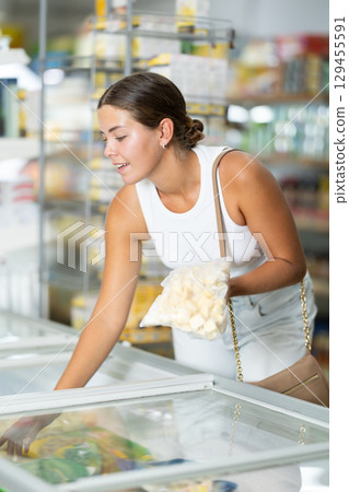 Young woman choosing frozen food in store 129455591