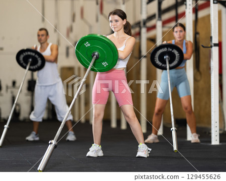Athletic young woman doing barbell exercises in crossfit gym 129455626
