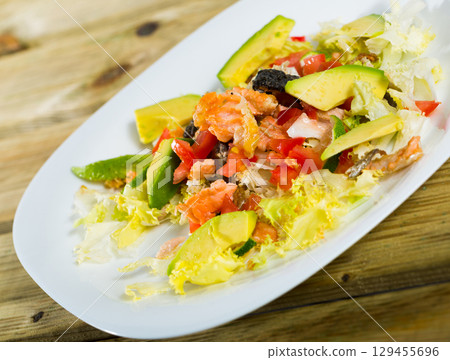 Salad with grilled salmon, avocado, tomatoes, lettuce 129455696