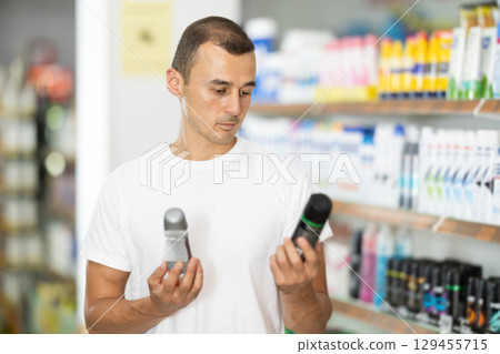 Man customer in store chooses interested in deodorant, Man customer in store chooses interested in deodorant, 129455715