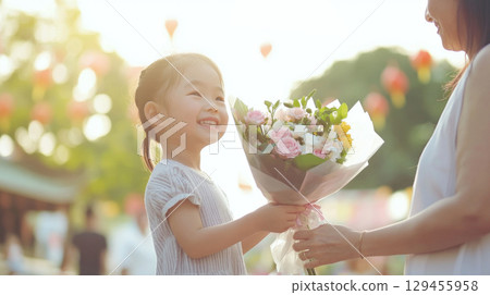 Asian woman receiving flower bouquet from her child, Mothers Day concept 129455958