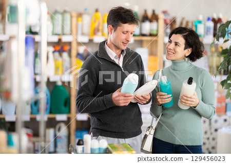 married couple chooses shower gel and shampoos 129456023