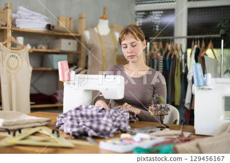 Woman tailor working at sewing machine 129456167