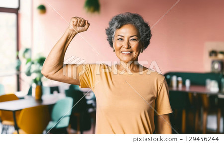 Middle aged hispanic woman with raised fist of empowerment, strength and women solidarity, International Womens Day concept 129456244