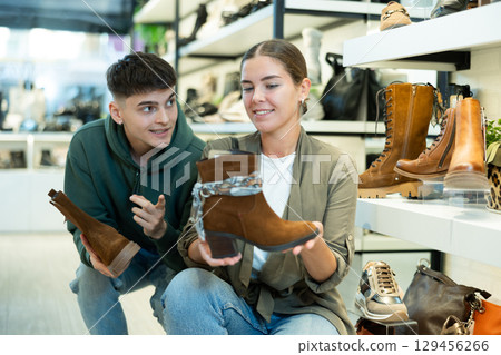 Young couple shopping for comfortable fall footwear in shoe store 129456266