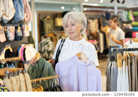 Woman flips through racks of hoodies 129456393