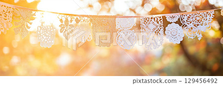 Traditional Mexican papel picado close-up with sunlight shining through 129456492