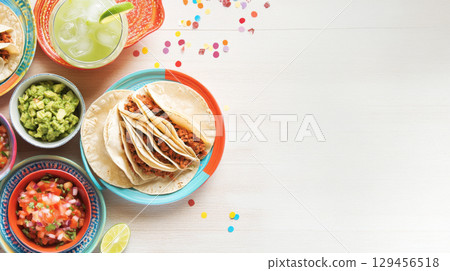 Cinco de Mayo tacos presented with traditional Mexican garnishes, background 129456518