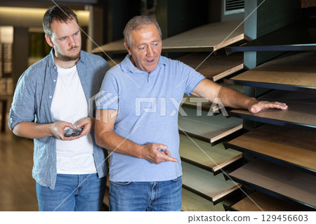 Elderly and young men choosing laminate sample 129456603