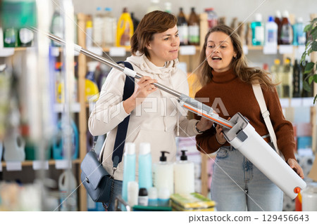 Two women choosing mop in department store 129456643