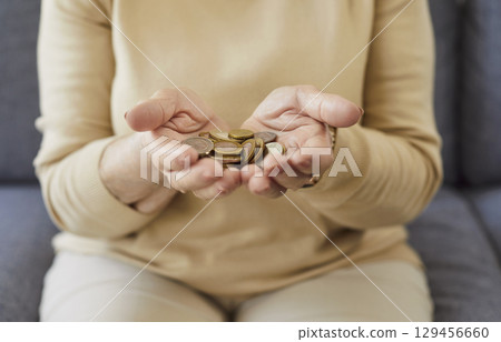Close-Up Of Senior Woman Hands Holding Coins Close-Up Of Senior Woman Hands Holding Coins 129456660