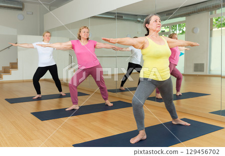 Group of active mature women practicing yoga Group of active mature women practicing yoga 129456702
