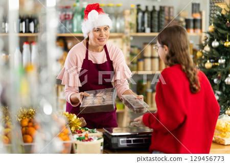Female employee sells cookies to teen girl Female employee sells cookies to teen girl 129456773