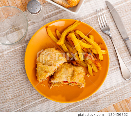Dish of Spanish cuisine is goat cheese and pepper booklets with French fries 129456862
