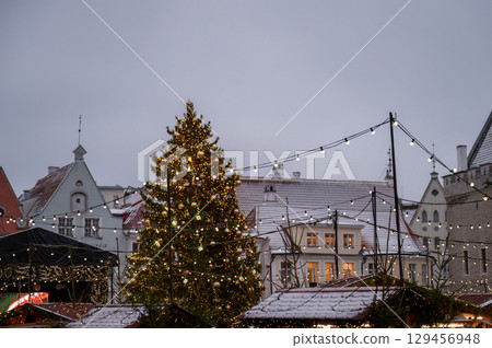 Christmas tree with festive lights at holiday market in snowy Tallinn old town Christmas tree with festive lights at holiday market in snowy Tallinn old town 129456948