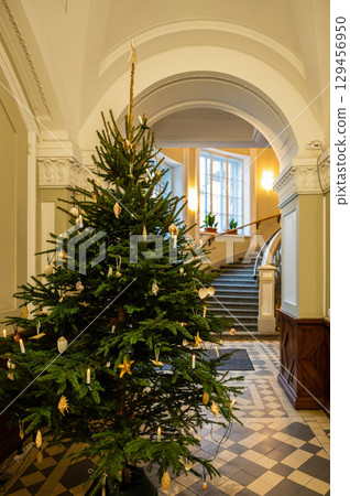 Decorated Christmas tree in elegant building interior with staircase 129456950