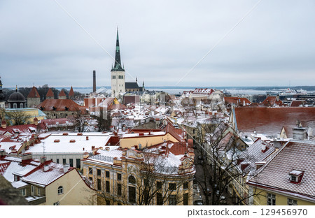 Winter panoramic view of snowy rooftops and St Olaf church in Tallinn old town 129456970