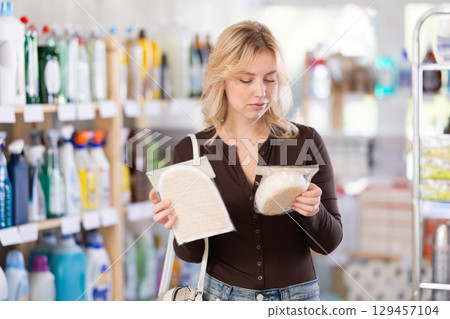 Positive young woman customer buying washcloth in store 129457104