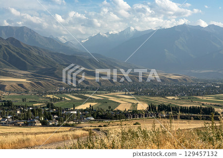 Kyrgyzstan autumn landscape. Village, agricultural fields and high mountains. Rural scene Kyrgyzstan autumn landscape. Village, agricultural fields and high mountains. Rural scene 129457132