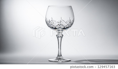 Luxury dining concept with empty crystal wine glass on gray background, beautiful vintage glassware with cut pattern for elegant restaurant or celebration theme Luxury dining concept with empty crystal wine glass on gray background, beautiful vintage glassware with cut pattern for elegant restaurant or celebration theme 129457163