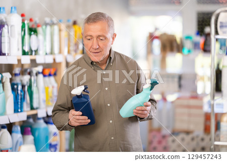 European man choosing spray in supermarket European man choosing spray in supermarket 129457243