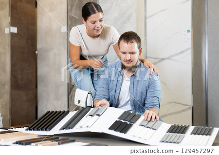 Couple man and woman choosing sample of house siding 129457297