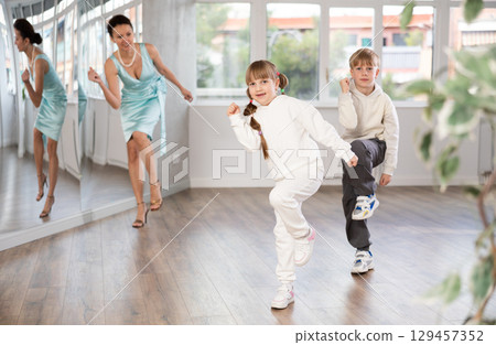 Boy and girl train to dance contemporary vigorous boogie woogie during classes. Boy and girl train to dance contemporary vigorous boogie woogie during classes. 129457352