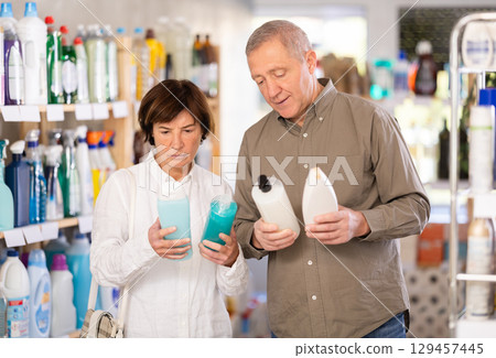 Couple man and woman choosing shampoo or shower gel in store Couple man and woman choosing shampoo or shower gel in store 129457445