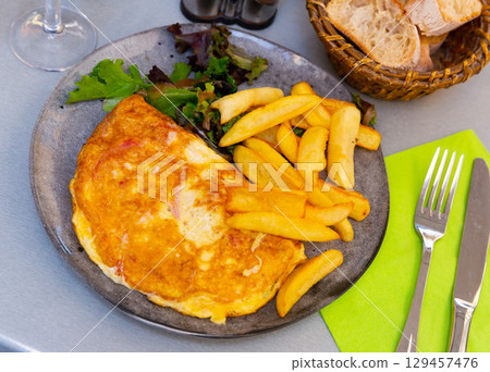 Portion of gourmet omelet with fried potatoes Portion of gourmet omelet with fried potatoes 129457476