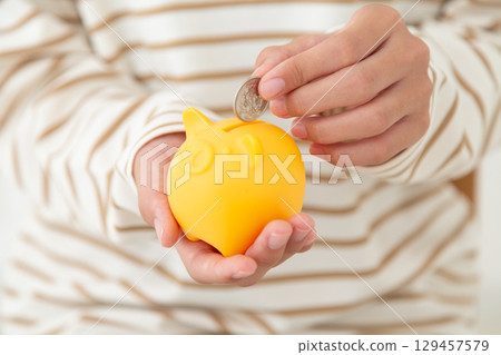 A middle school girl with a piggy bank 129457579