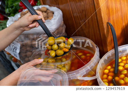 Customer putting pickled green olives in box 129457619
