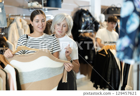 Ladies carefully select sweaters 129457621