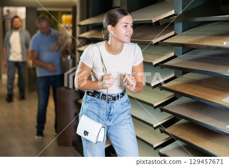 Young woman choosing laminate flooring sample Young woman choosing laminate flooring sample 129457671
