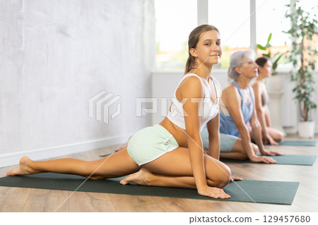 Womens different ages practicing yoga lesson at sport club 129457680