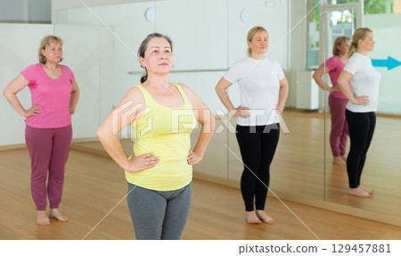 Group of active mature women practicing yoga Group of active mature women practicing yoga 129457881