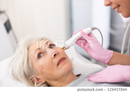 Old woman having face radiolifting procedure 129457894