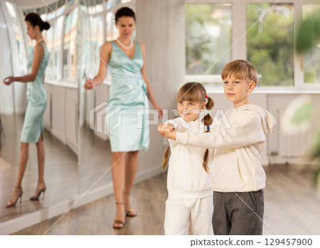 Tween dancers, girl and boy practicing waltz in dance studio Tween dancers, girl and boy practicing waltz in dance studio 129457900