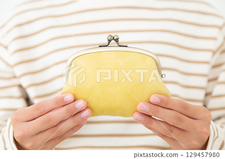 一名國中生拿著一個黃色扣式錢包 129457980
