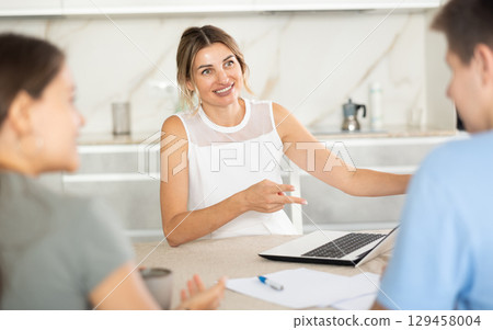 Woman manager tells clients about specifics of design of microloan, about benefits and advantages Woman manager tells clients about specifics of design of microloan, about benefits and advantages 129458004