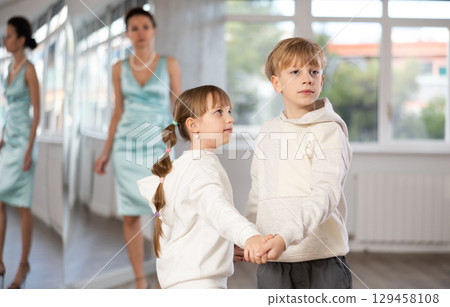 Boy and girl in sport wear train to dance contemporary vigorous rumba during classes. Boy and girl in sport wear train to dance contemporary vigorous rumba during classes. 129458108