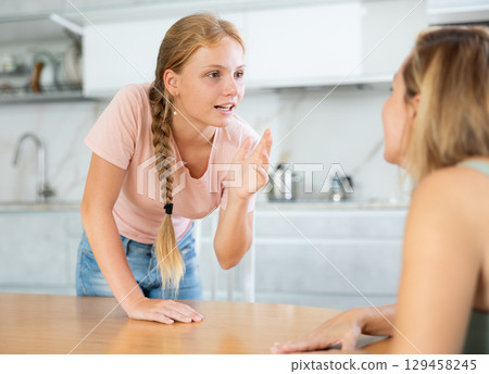Teenage daughter enthusiastically tells unrecognizable mother about planned vacation with friends Teenage daughter enthusiastically tells unrecognizable mother about planned vacation with friends 129458245