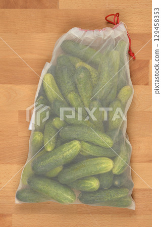 Pickling cucumbers inside a reusable mesh bag 129458353
