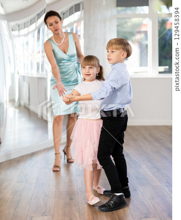 Boy and girl in pair train to dance contemporary vigorous waltz during classes. 129458394