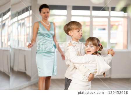 Tween dancers, girl and boy practicing waltz in dance studio Tween dancers, girl and boy practicing waltz in dance studio 129458418